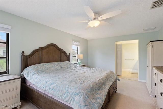 carpeted bedroom with ceiling fan, a textured ceiling, connected bathroom, and multiple windows