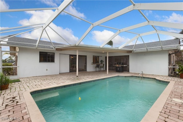 back of property featuring glass enclosure and a patio