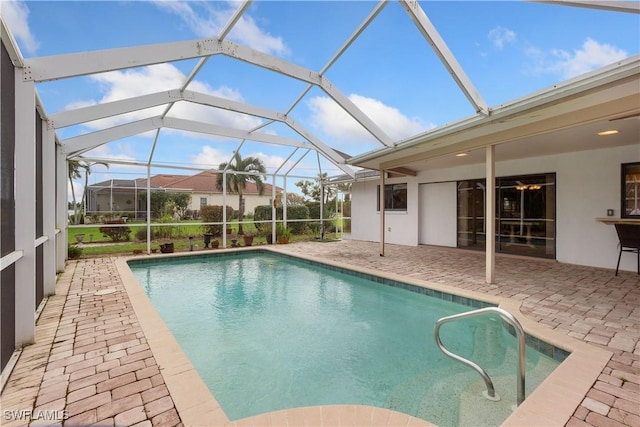 view of swimming pool featuring glass enclosure and a patio