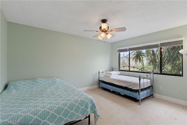 bedroom with carpet flooring, ceiling fan, and a textured ceiling