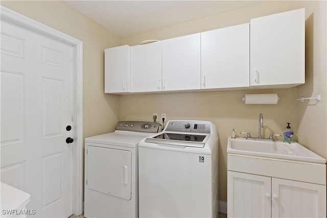 washroom featuring cabinets, independent washer and dryer, and sink