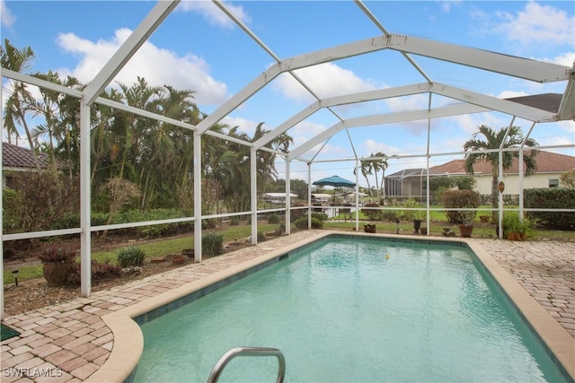 view of swimming pool featuring a patio area and a lanai