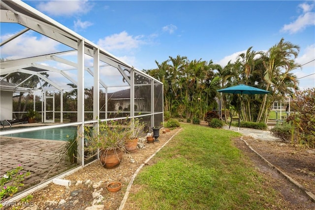 view of yard featuring a lanai, a patio area, and an outdoor pool