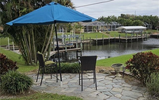 view of dock with a water view and a lawn