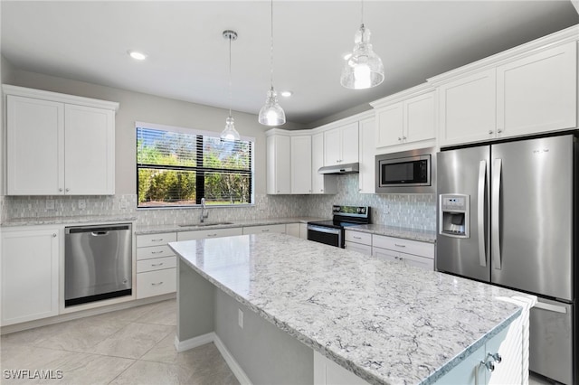 kitchen featuring appliances with stainless steel finishes, sink, a kitchen island, pendant lighting, and white cabinets