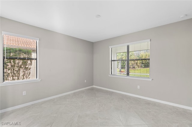 unfurnished room featuring light tile patterned floors and plenty of natural light