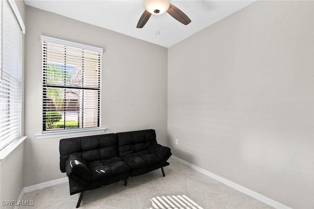 living area with ceiling fan and light tile patterned flooring