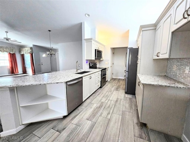 kitchen with pendant lighting, tasteful backsplash, white cabinetry, kitchen peninsula, and stainless steel appliances