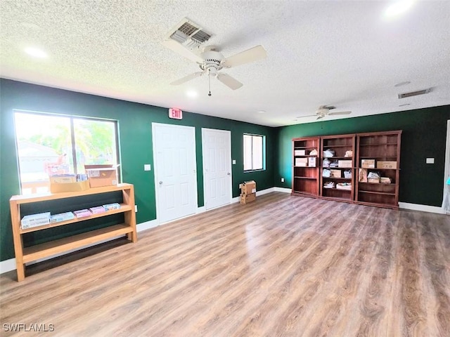 living room with hardwood / wood-style floors, a textured ceiling, and ceiling fan