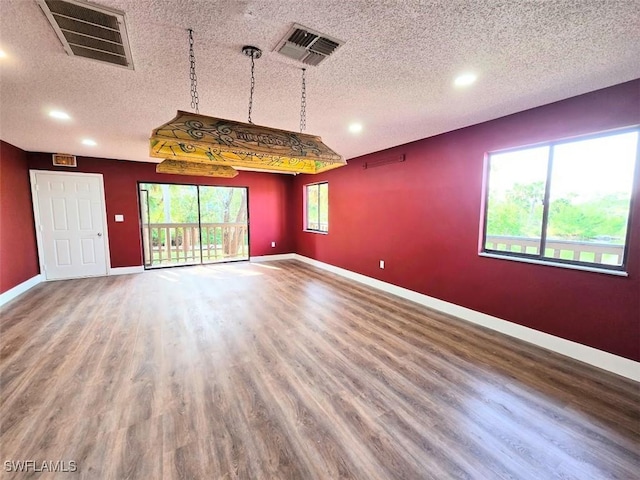 interior space featuring wood-type flooring and a textured ceiling