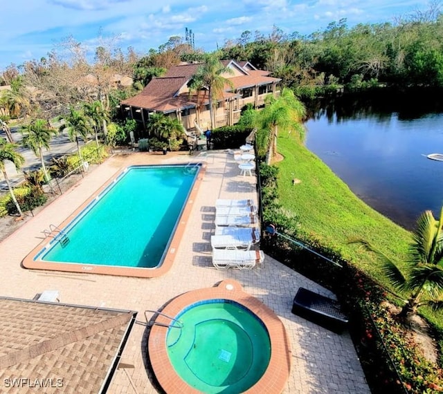 view of swimming pool featuring a patio area, a community hot tub, and a water view