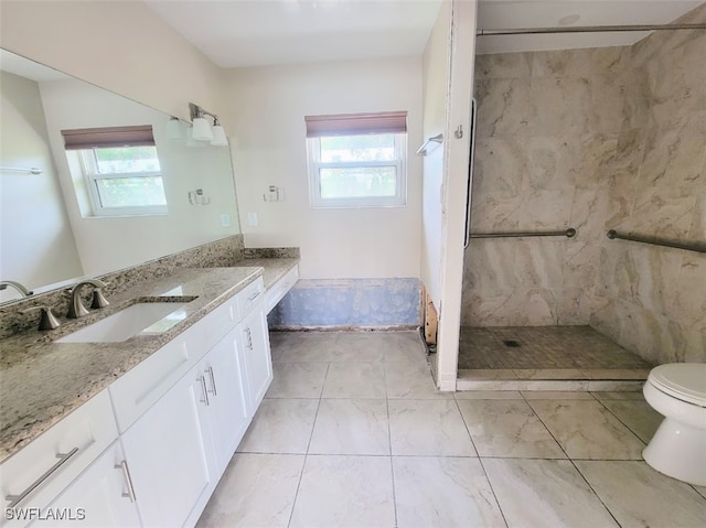 bathroom featuring toilet, a shower, and vanity