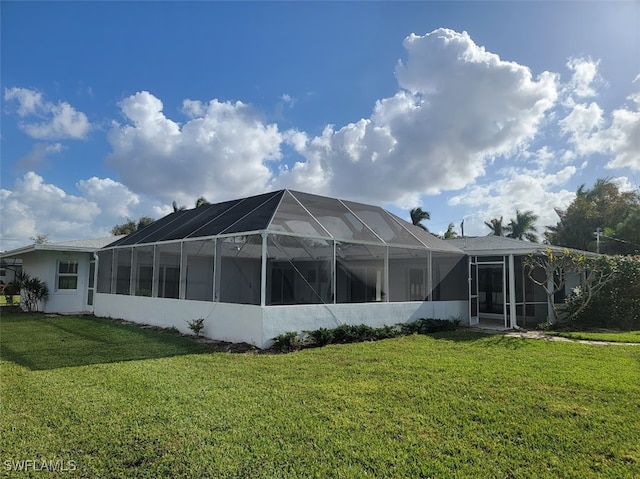 back of house with a lanai and a yard