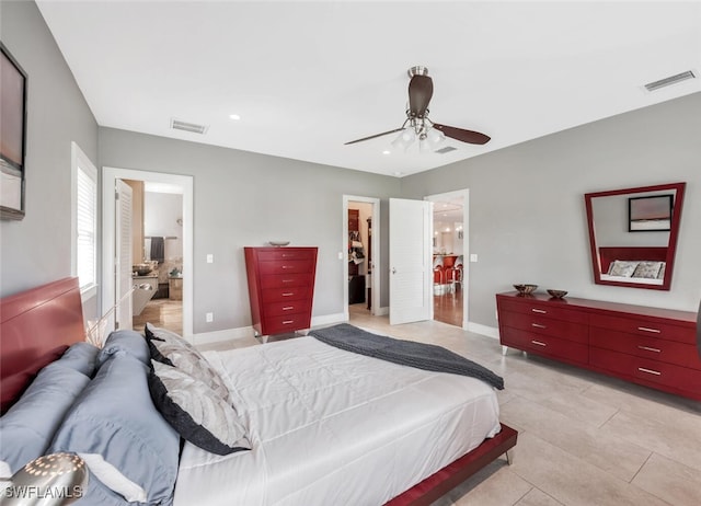 tiled bedroom featuring a walk in closet, a closet, connected bathroom, and ceiling fan