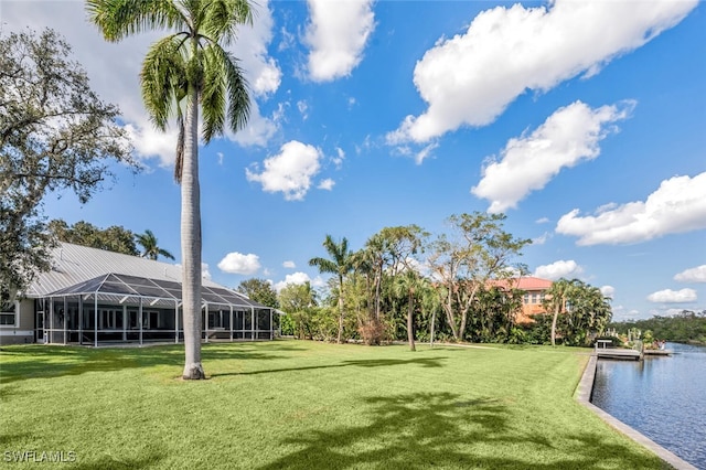 view of property's community with a water view and a lawn