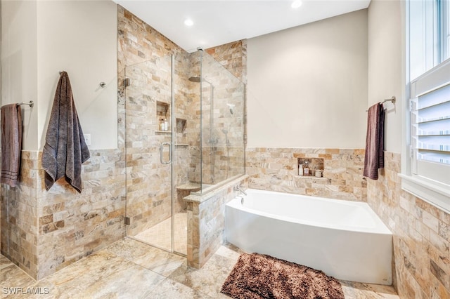 bathroom featuring tile walls and shower with separate bathtub