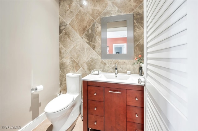 bathroom featuring vanity, toilet, and tasteful backsplash