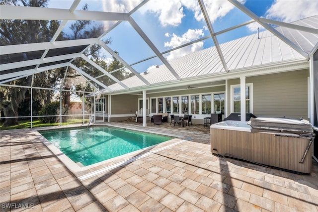 view of pool featuring grilling area, ceiling fan, a hot tub, a lanai, and a patio area