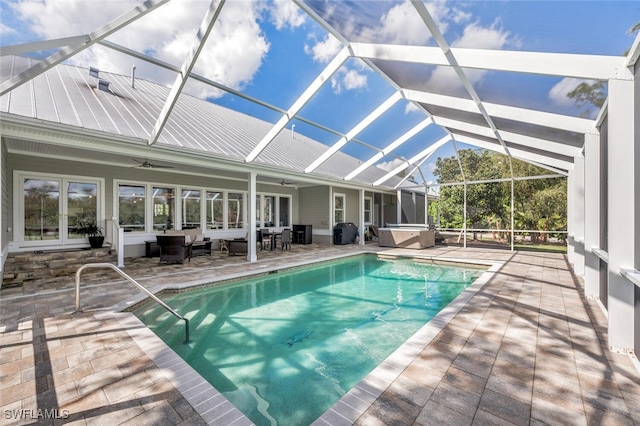 view of pool with a hot tub, a patio area, a lanai, ceiling fan, and an outdoor living space