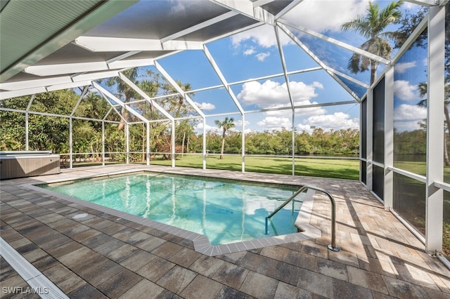 view of swimming pool with a hot tub, a lanai, a patio, and a lawn