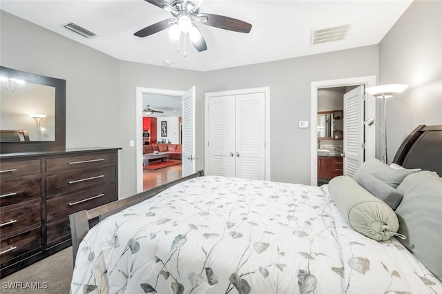 bedroom with light hardwood / wood-style floors, a closet, connected bathroom, and ceiling fan