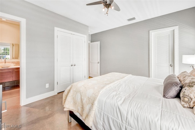 bedroom with two closets, sink, ensuite bath, and ceiling fan