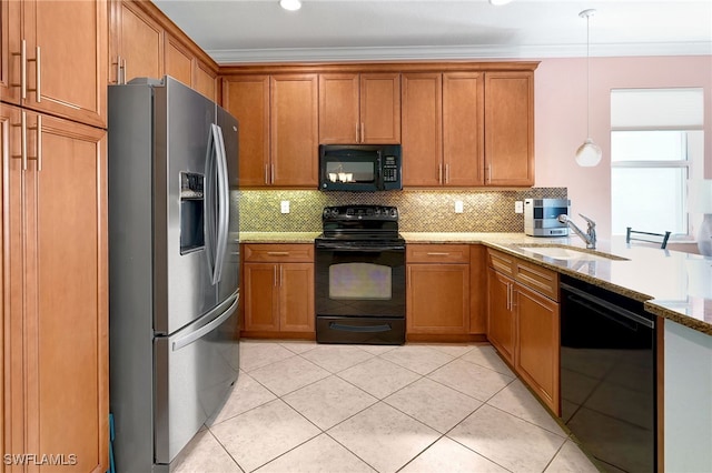 kitchen featuring decorative backsplash, light stone countertops, black appliances, pendant lighting, and sink