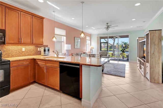 kitchen featuring sink, black appliances, kitchen peninsula, and decorative light fixtures