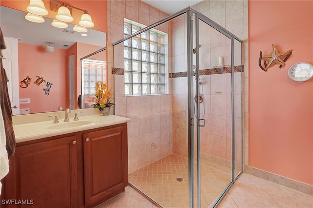 bathroom with vanity, a shower with shower door, and tile patterned floors