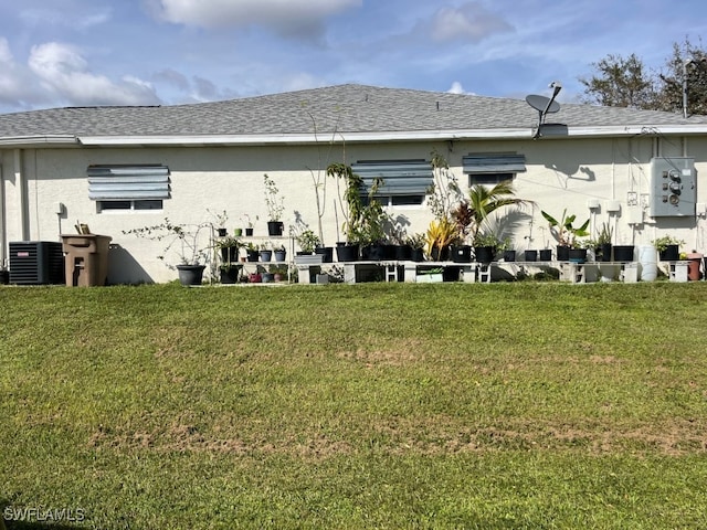 back of property with a yard and central AC unit