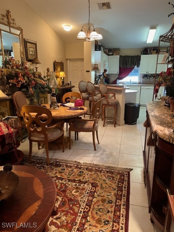 dining space featuring light tile patterned flooring and a notable chandelier