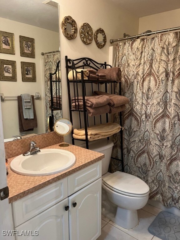 bathroom featuring vanity, a shower with curtain, toilet, and tile patterned flooring