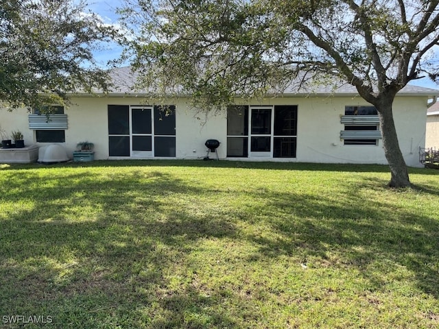 back of property featuring a lawn