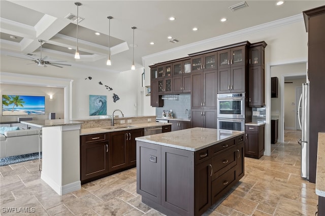 kitchen with coffered ceiling, dark brown cabinets, a large island, sink, and decorative light fixtures