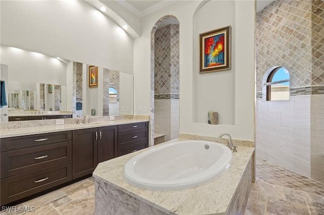 bathroom featuring vanity, a relaxing tiled tub, and crown molding