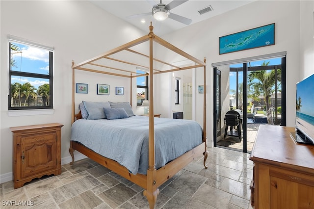 bedroom featuring multiple windows, a towering ceiling, and ceiling fan