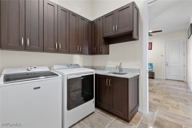 clothes washing area featuring sink, washer and clothes dryer, ceiling fan, and cabinets