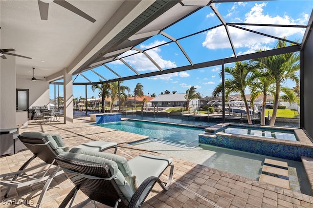 view of swimming pool with an in ground hot tub, a patio, a lanai, ceiling fan, and pool water feature