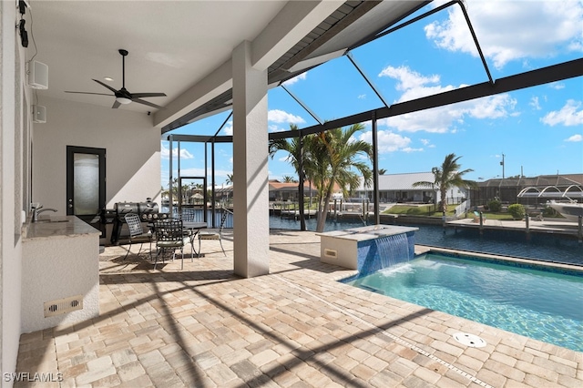 view of swimming pool featuring a patio area, a lanai, a water view, and pool water feature