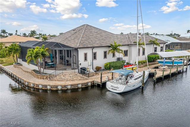 back of house with a water view and glass enclosure