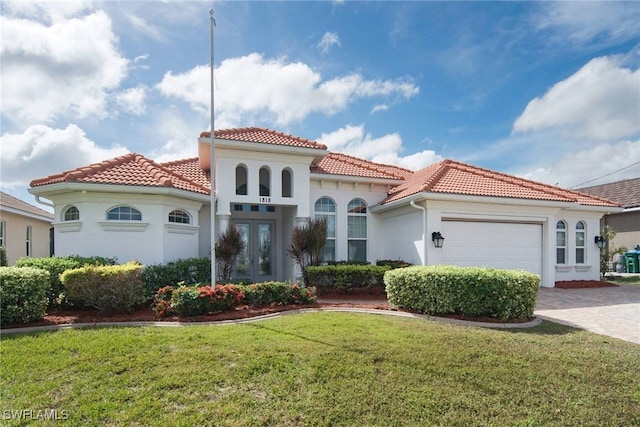 mediterranean / spanish-style home featuring a front lawn and a garage