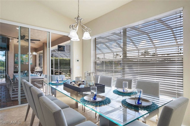 dining area featuring lofted ceiling and ceiling fan with notable chandelier