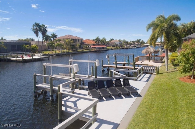 view of dock featuring a water view and a lawn