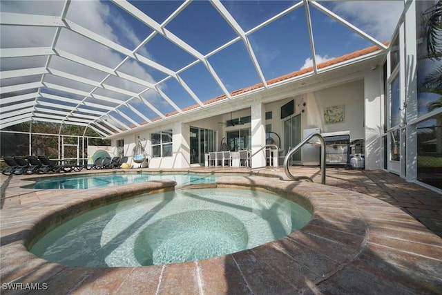 view of swimming pool featuring an in ground hot tub, ceiling fan, a patio, and a lanai