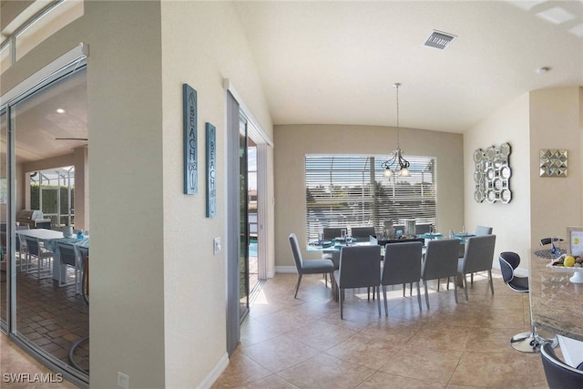 dining space with vaulted ceiling, a notable chandelier, a healthy amount of sunlight, and light tile patterned floors