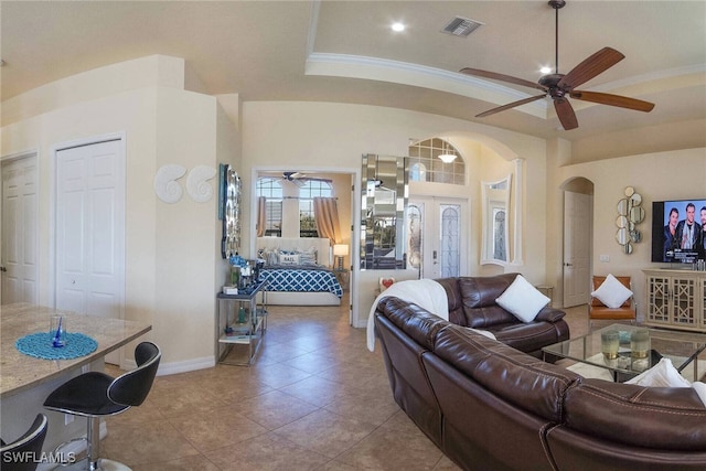 living room with ornamental molding, light tile patterned flooring, and ceiling fan