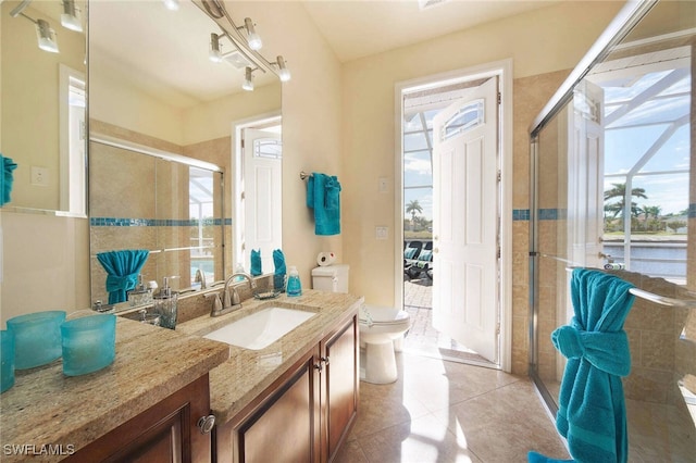 bathroom featuring vanity, toilet, a shower with shower door, and tile patterned flooring