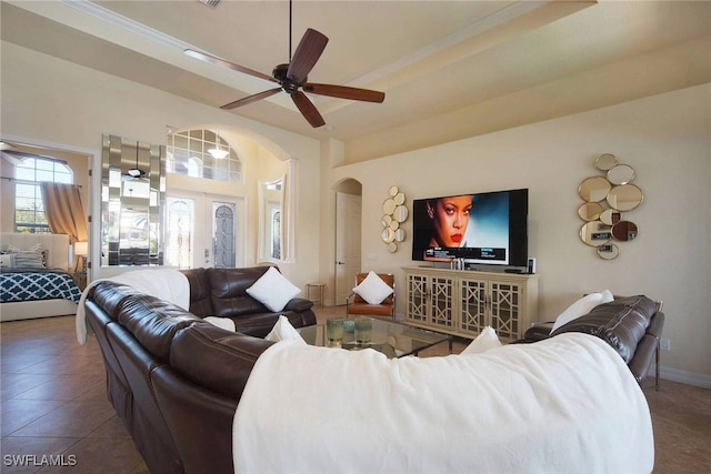 living room featuring dark tile patterned flooring, ceiling fan, a towering ceiling, and french doors