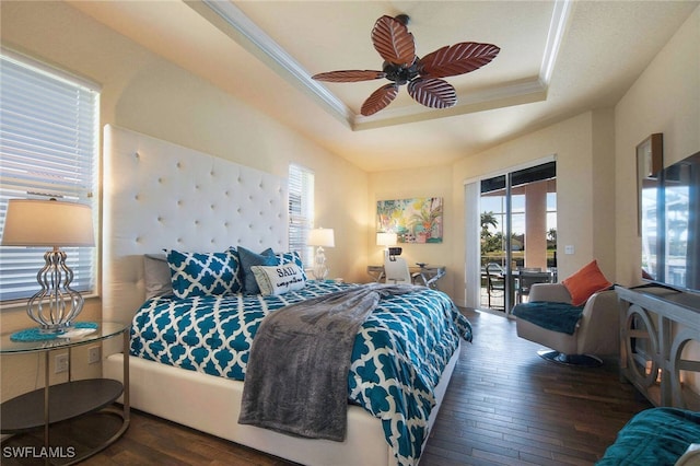 bedroom featuring ceiling fan, a raised ceiling, ornamental molding, and dark hardwood / wood-style flooring