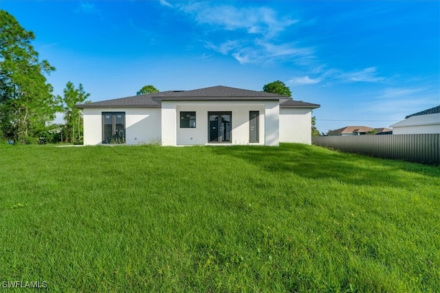 rear view of house featuring a yard